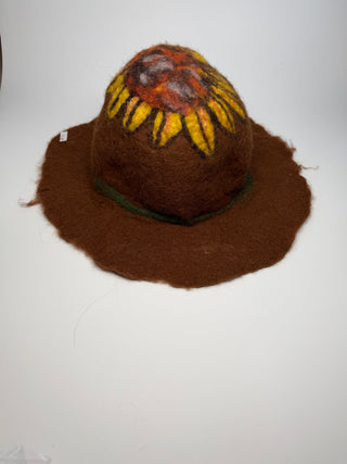 A brown felt hat with a wide brim, featuring a painted sunflower motif on the crown and a dark green band around the base.